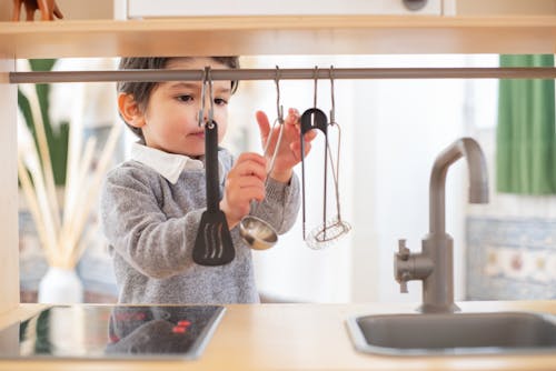 Free A Boy Playing with a Kitchen Set Toys Stock Photo