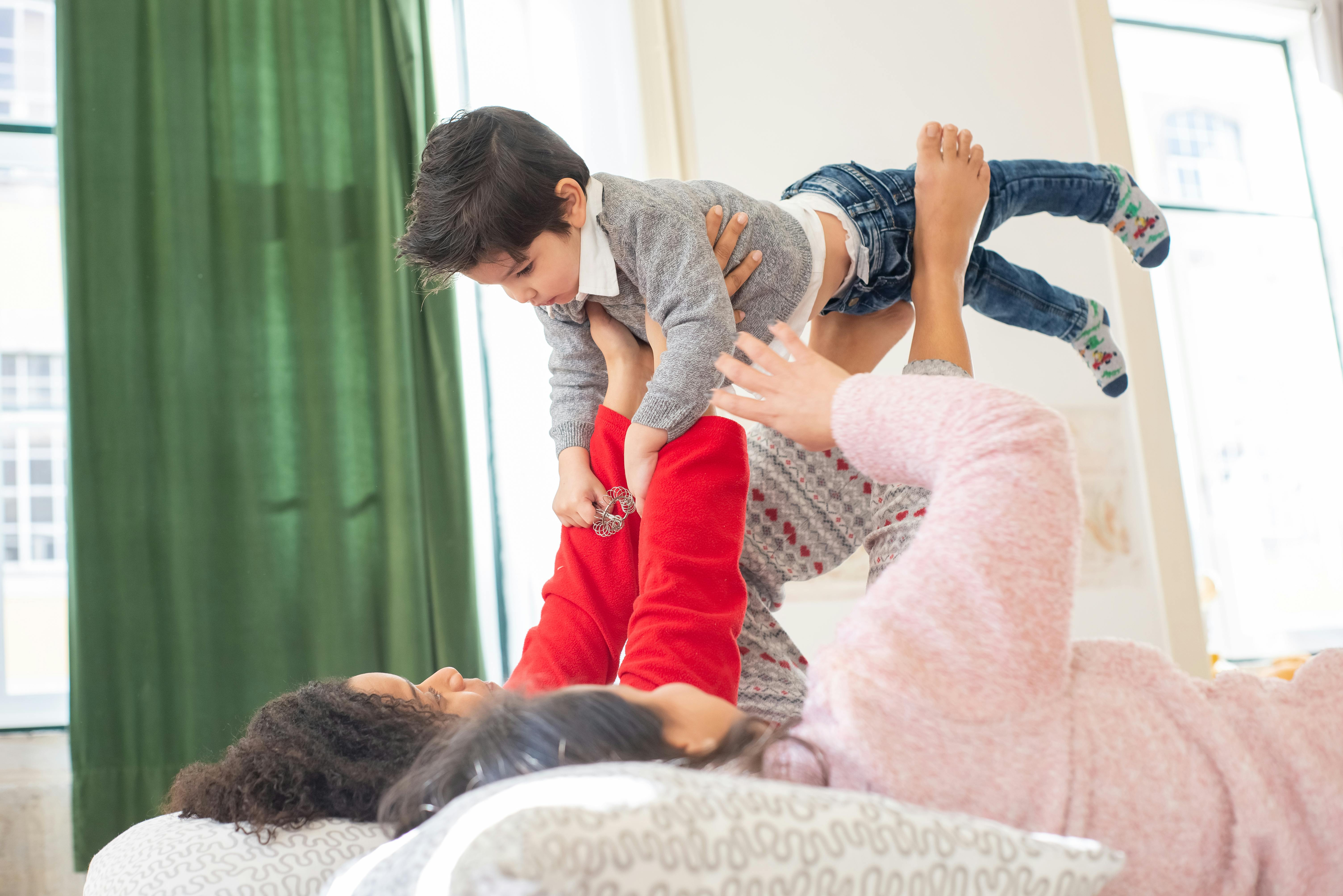 women couple in bed playing with a child