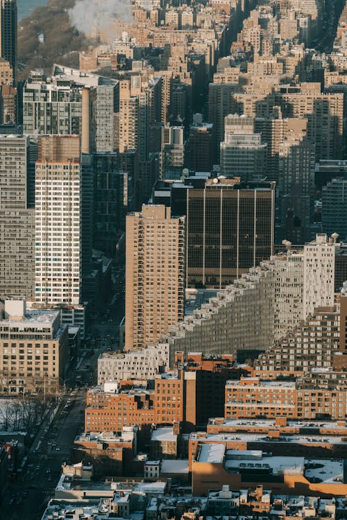 Free Drone view of densely build district of metropolis with high skyscrapers nearby residential buildings in winter day Stock Photo