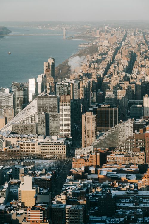 Free Modern tall buildings and residential houses located on street near waterfront with calm sea in coastal area of contemporary city Stock Photo