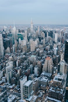 A breathtaking aerial shot of New York City with snow-covered skyscrapers and a clear skyline, capturing urban winter beauty.