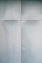 Full frame background of white textured wall with simple finishing panels and lines of modern residential building located on street