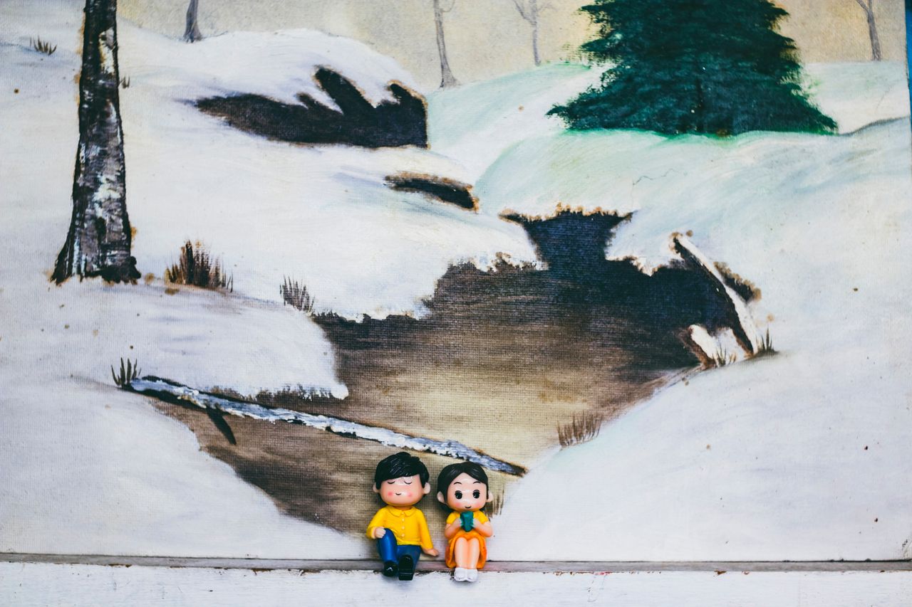 figures of woman with boyfriend sitting against canvas with painting o