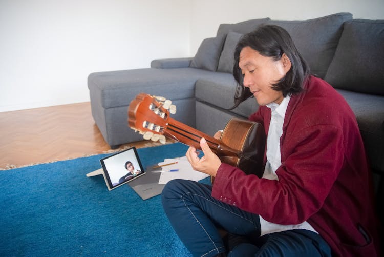 A Man Teaching Guitar Lessons Online