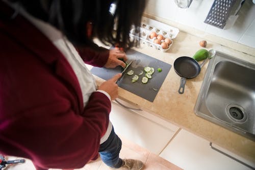 Free A Person Slicing Cucumber with a Knife Stock Photo