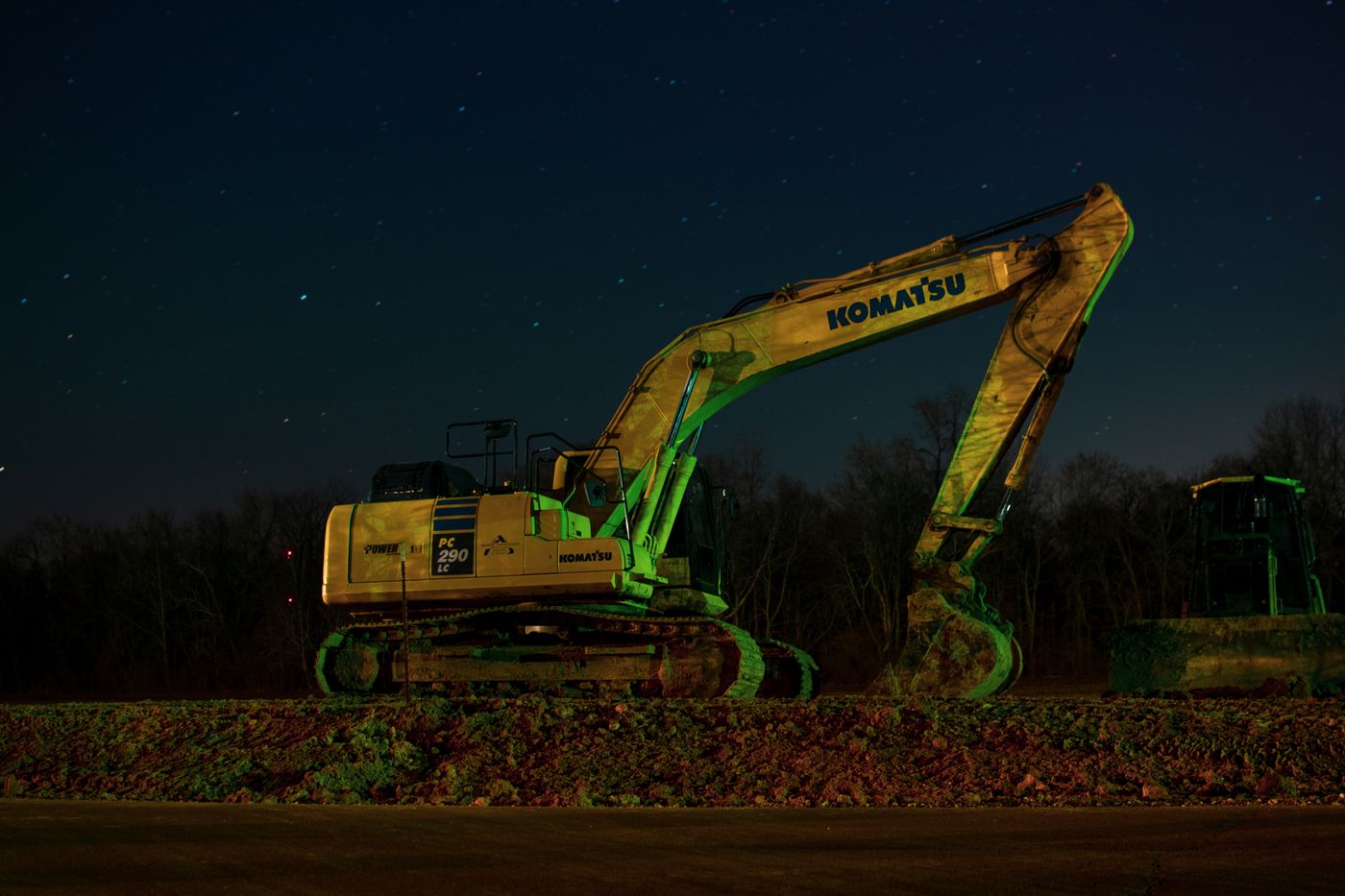 Excavator parked on a construction site at night