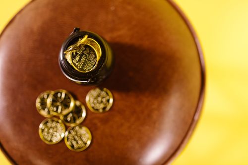 Free Overhead shot of gold coins on a brown surface against a yellow background. Stock Photo