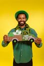 Smiling Man wearing a Green Hat holding a Prop