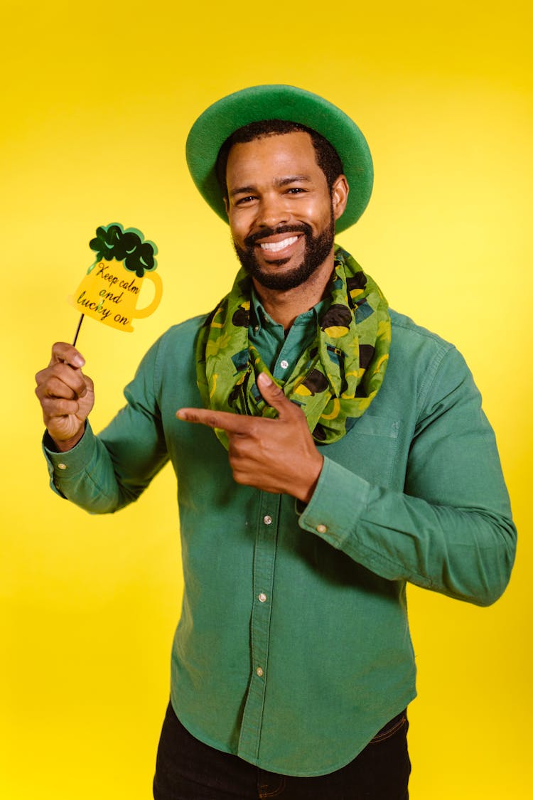 Smiling Man Wearing Green Hat Holding A Prop 