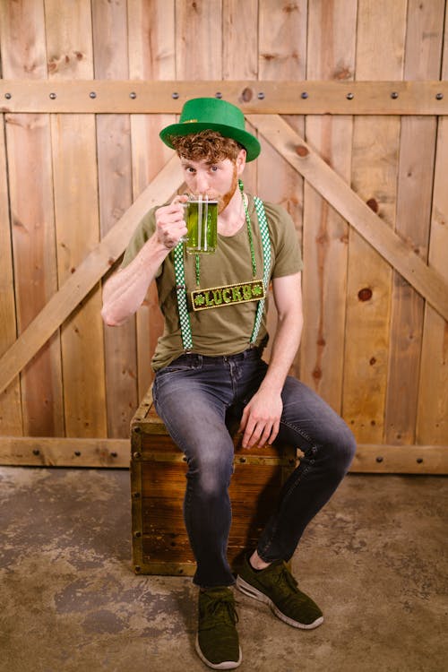 Man wearing a Green Hat drinking Green Beer 