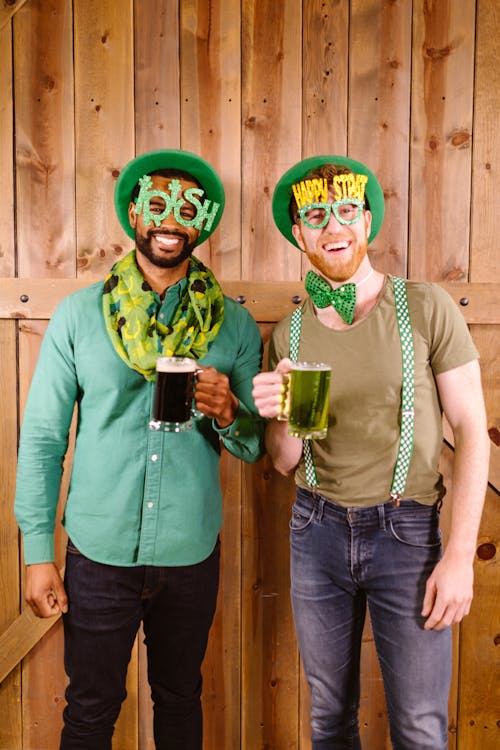 Free Smiling Men holding Clear Glass Mug with Green Beer  Stock Photo