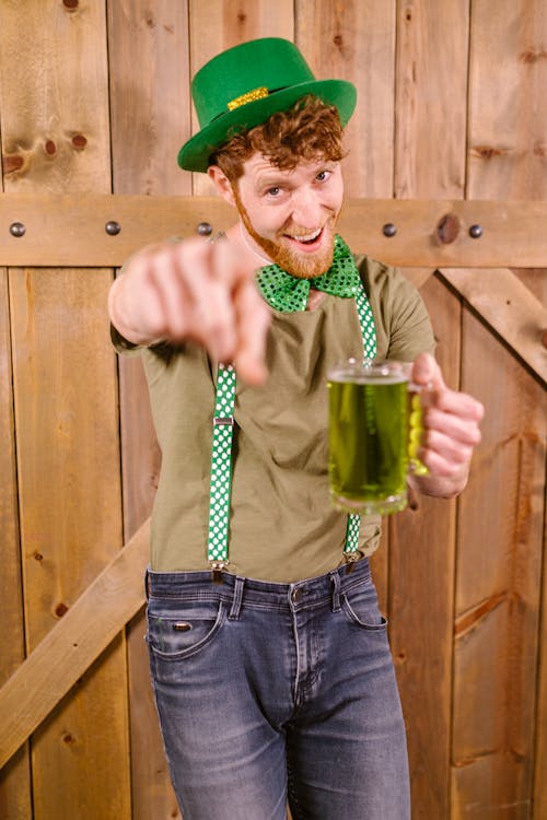 Man in Green and White Long Sleeve Shirt Holding Glass Mug