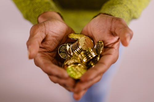 Free Gold Coins in Person's Hands Stock Photo