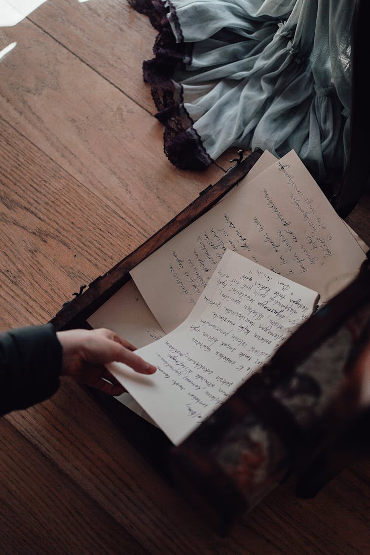 Unrecognizable Person With Letters In Old Suitcase