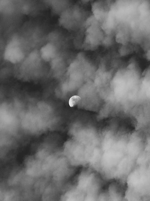 Grayscale Photo of Moon in Dark Clouds