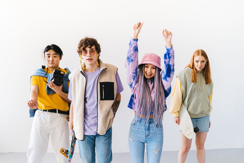 Fotomural Un grupo diverso y elegante de jóvenes adultos posando con patinetas en un estudio.