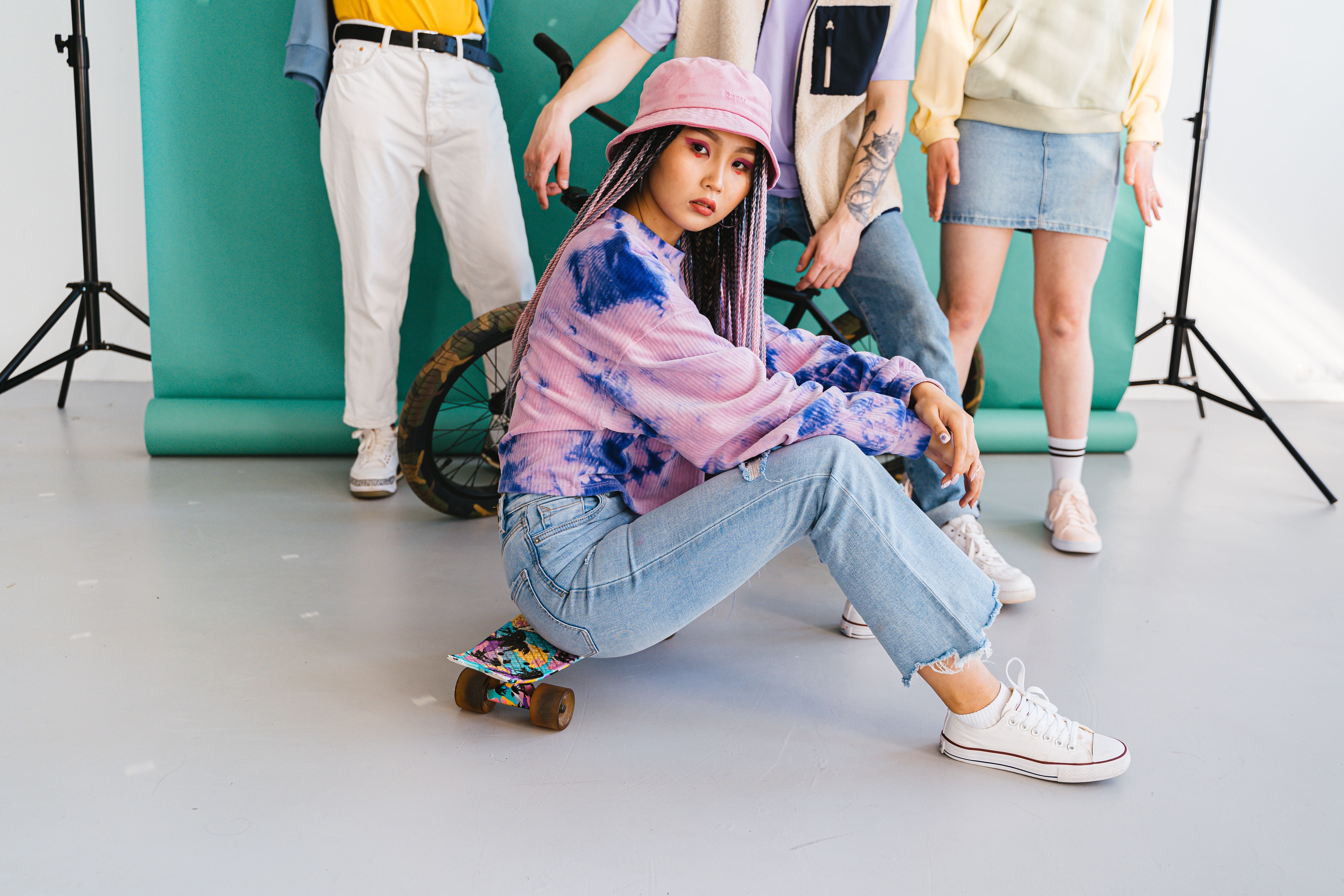 Woman Wearing a Bucket Hat Sitting on a Skateboard