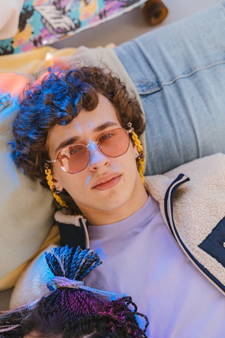 A Man Wearing Clear Colored Sunglasses Lying On His Back 