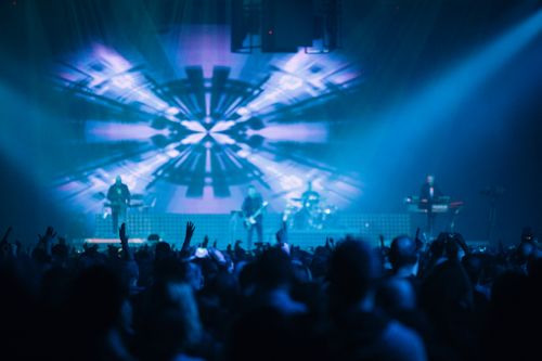 Free A vibrant scene of a live concert with lights and an enthusiastic crowd. Stock Photo