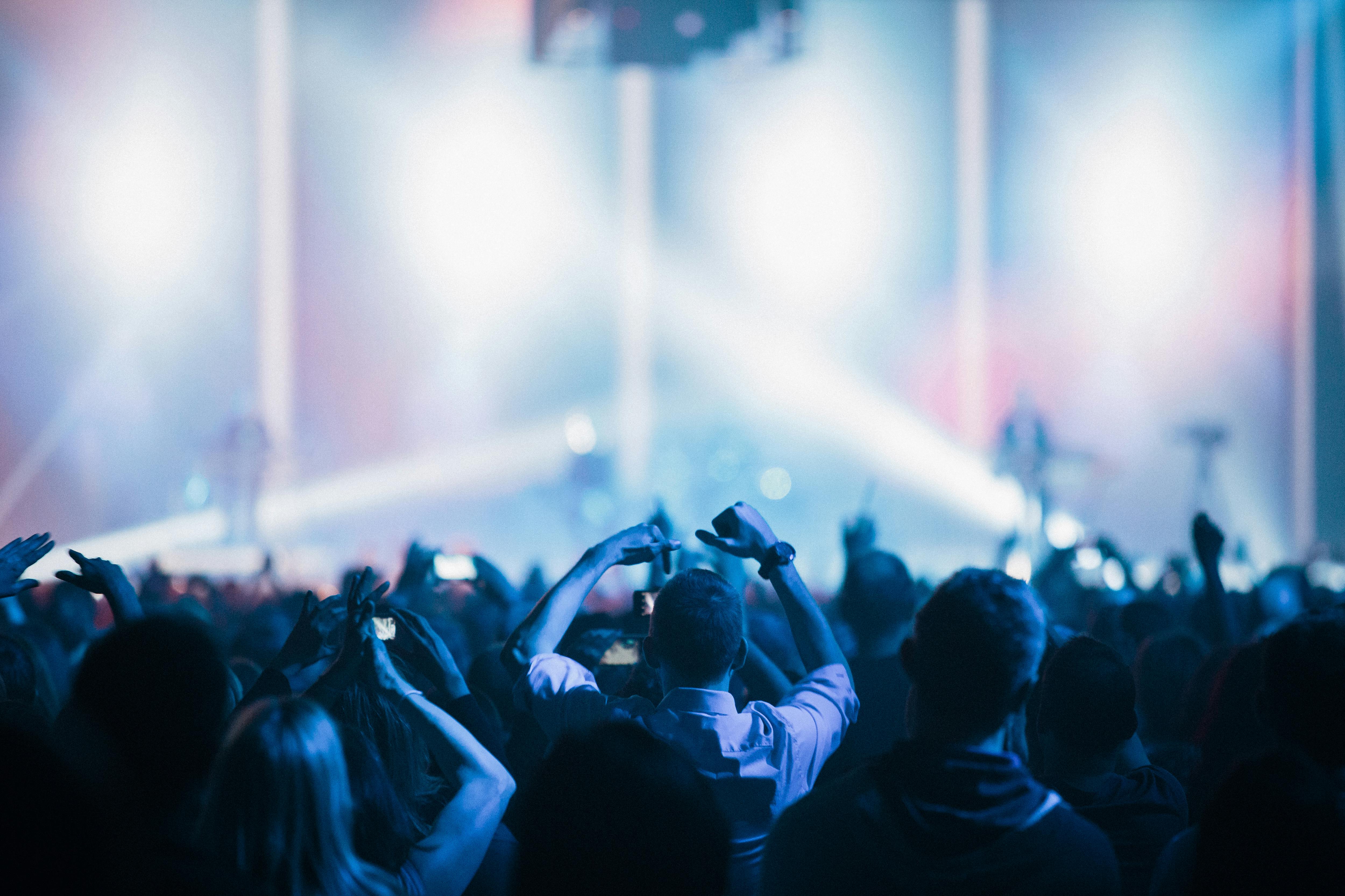 Vibrant live concert scene featuring an enthusiastic crowd enjoying a captivating performance under colorful stage lights.