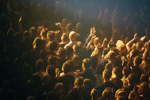 Free A vibrant crowd enjoying a live music concert with hands raised in excitement. Stock Photo