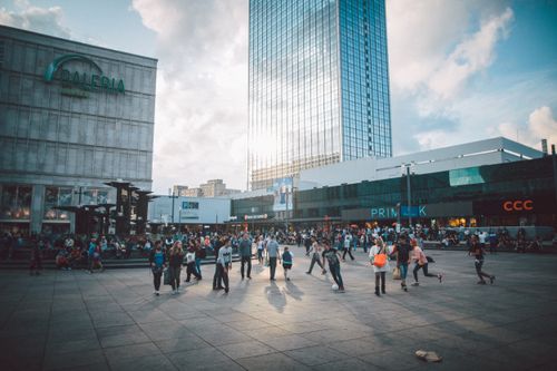 Free Crowd enjoying a sunny day at Alexanderplatz, Berlin with Galeria and Skyscraper in view. Stock Photo
