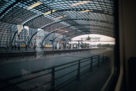 Interior view of Berlin Hauptbahnhof with arched glass ceiling and platforms.