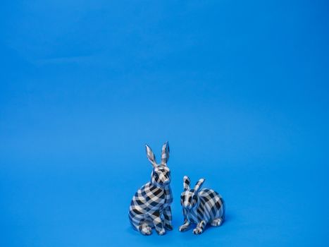 Decorative checkered rabbits on a blue background perfect for Easter themes.