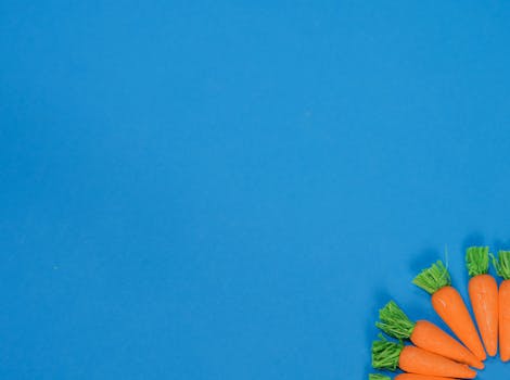 A vibrant blue background featuring a decorative arrangement of carrots for seasonal celebrations.
