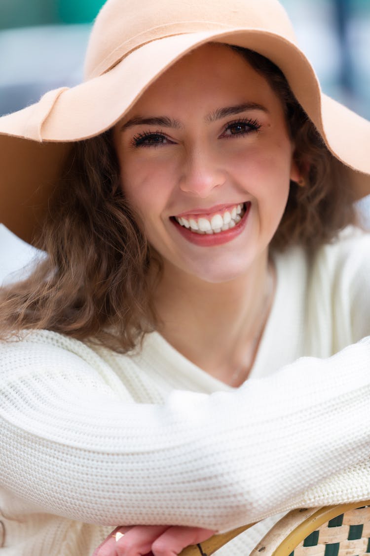 Portrait Of A Beautiful Woman Smiling Wearing A White And A Hat