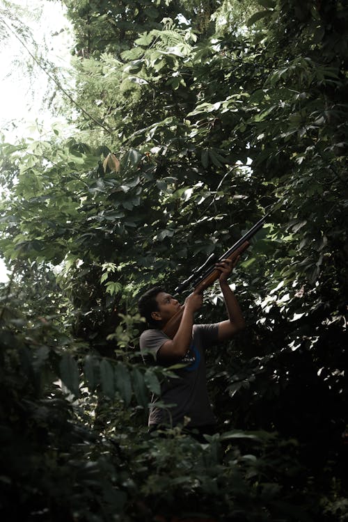 A Man Using a Rifle in the Forest
