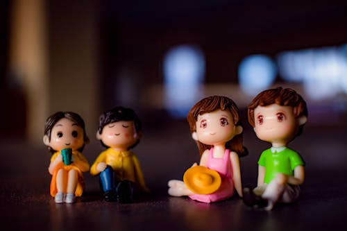 Free Small colorful figurines of cute couples with boys and girls placed on surface in light room on blurred background at home Stock Photo