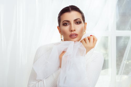 Close-up Photo of an Elegant Woman in White Sheer Top 