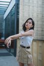 Woman in White Top with Khaki Skirt Standing With Crisscrossing Arms