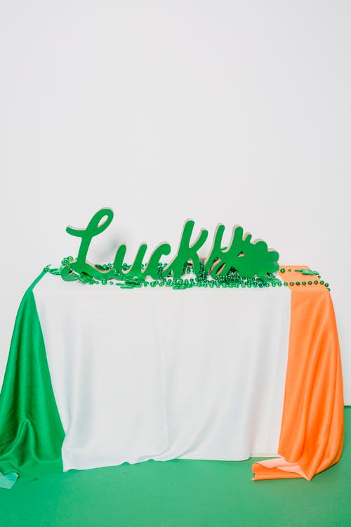 Free Composition of green inscription placed with green beads on national flag of Ireland on white and green background Stock Photo