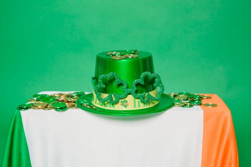 Green hat and coins on table with Irish flag