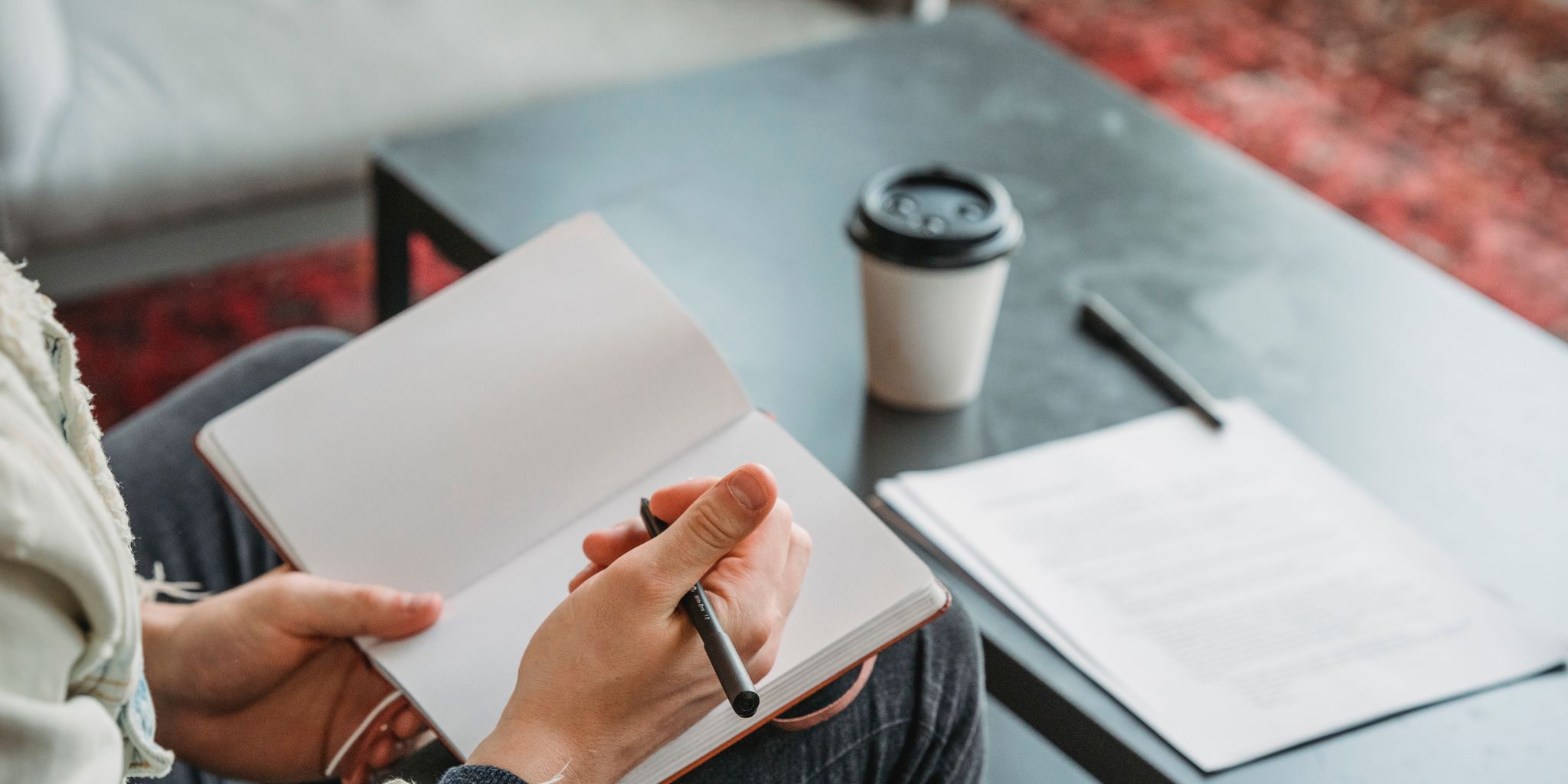 Writer working at a desk with a notebook and laptop