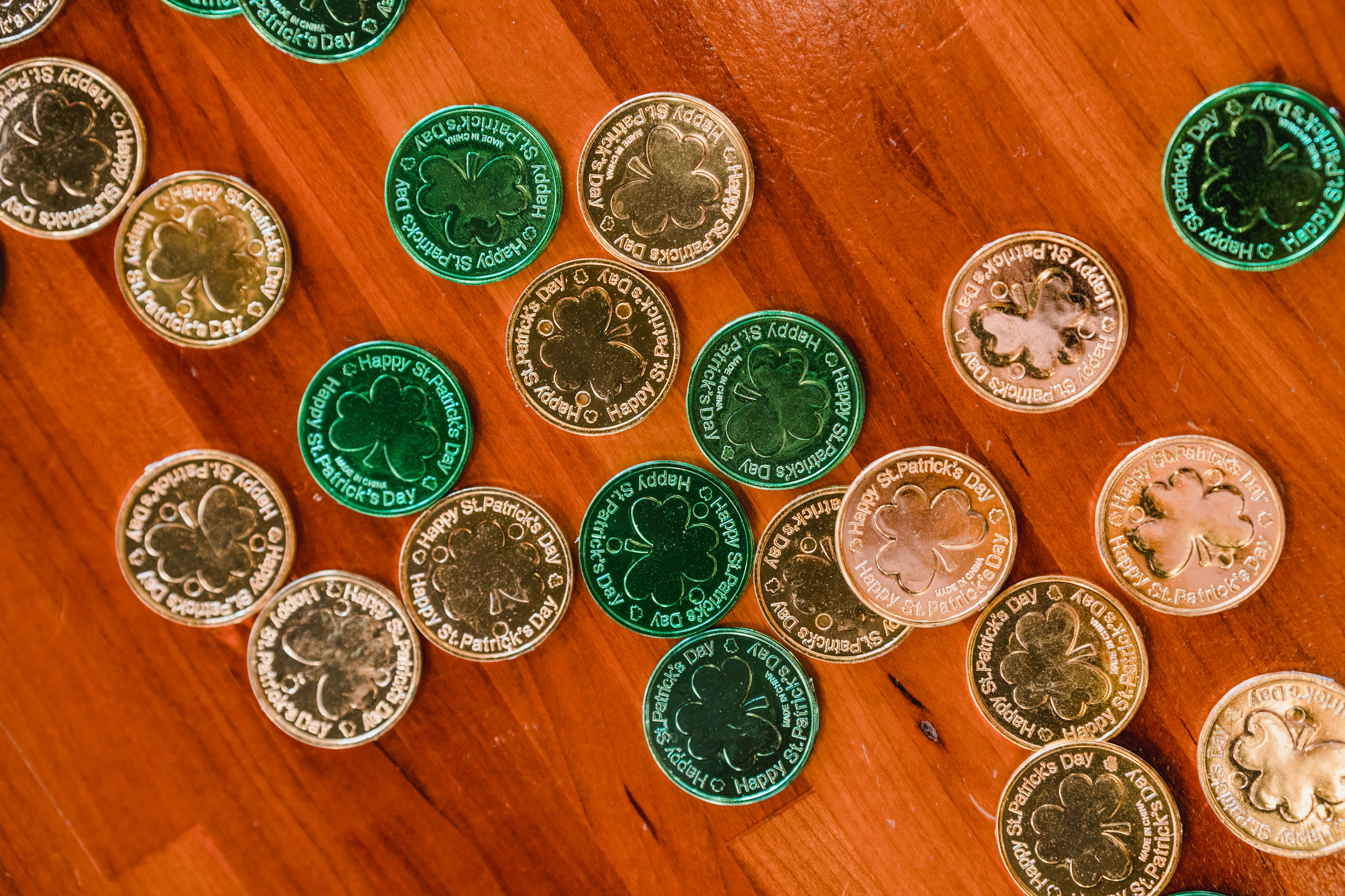 golden and green st patricks day coins on wooden floor