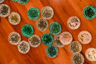 Golden and green St Patricks day coins on wooden floor