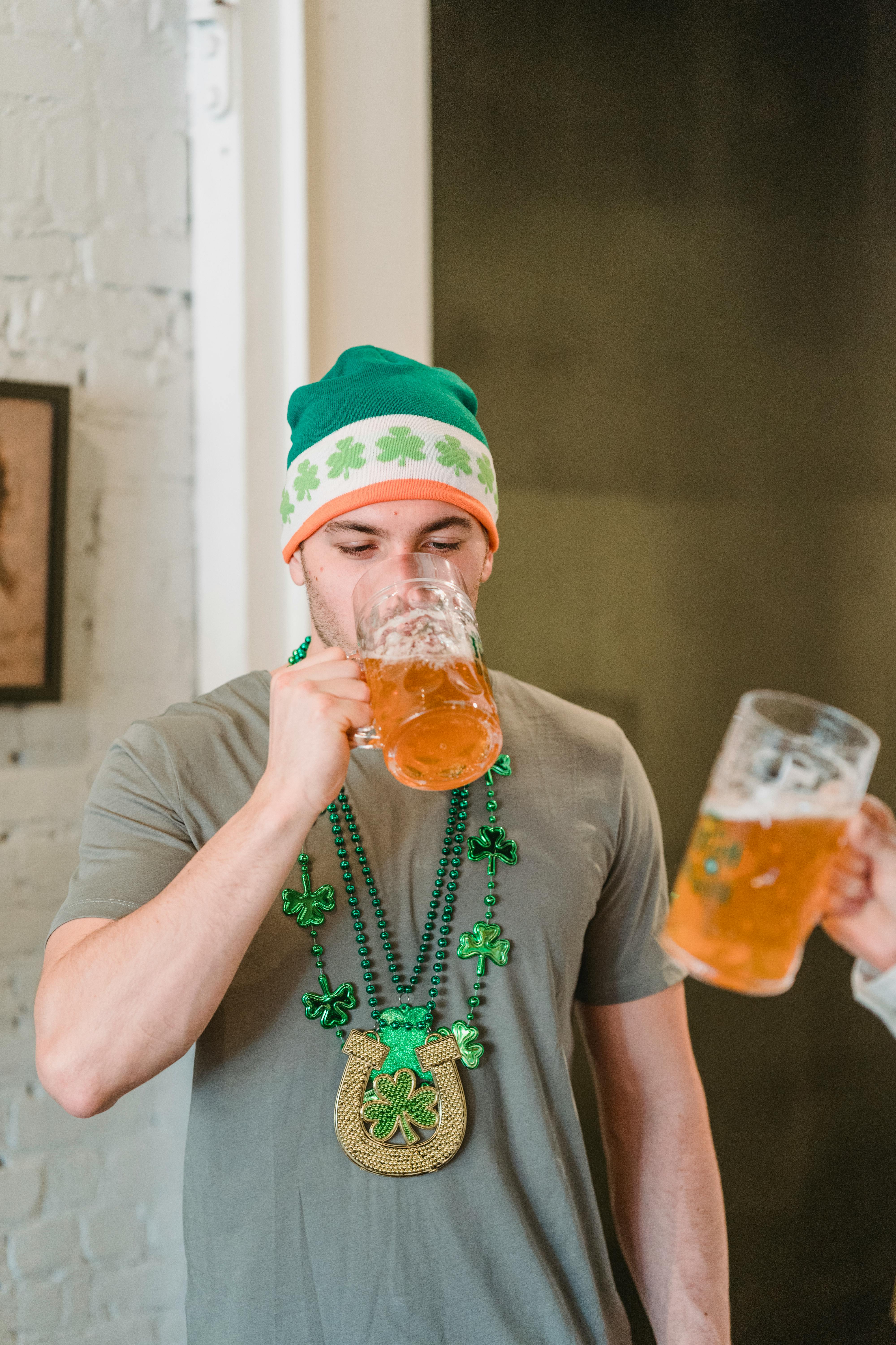 man in st patricks day hat drinking beer with friend