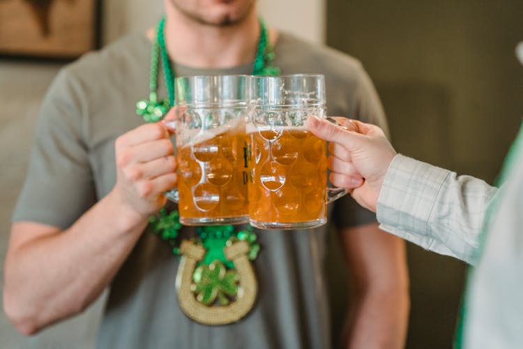 Hands Toasting Clear Glass Mugs With Brown Liquid