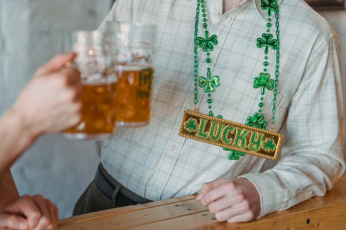 Free Person Wearing Green Necklace Toasting Beer Mug Stock Photo
