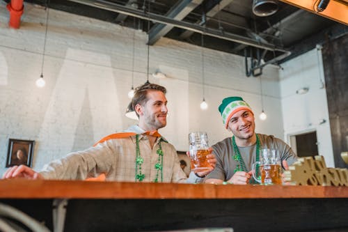 Low-Angle Shot of Two Men at the Bar while Celebrating Saint Patrick's Day 