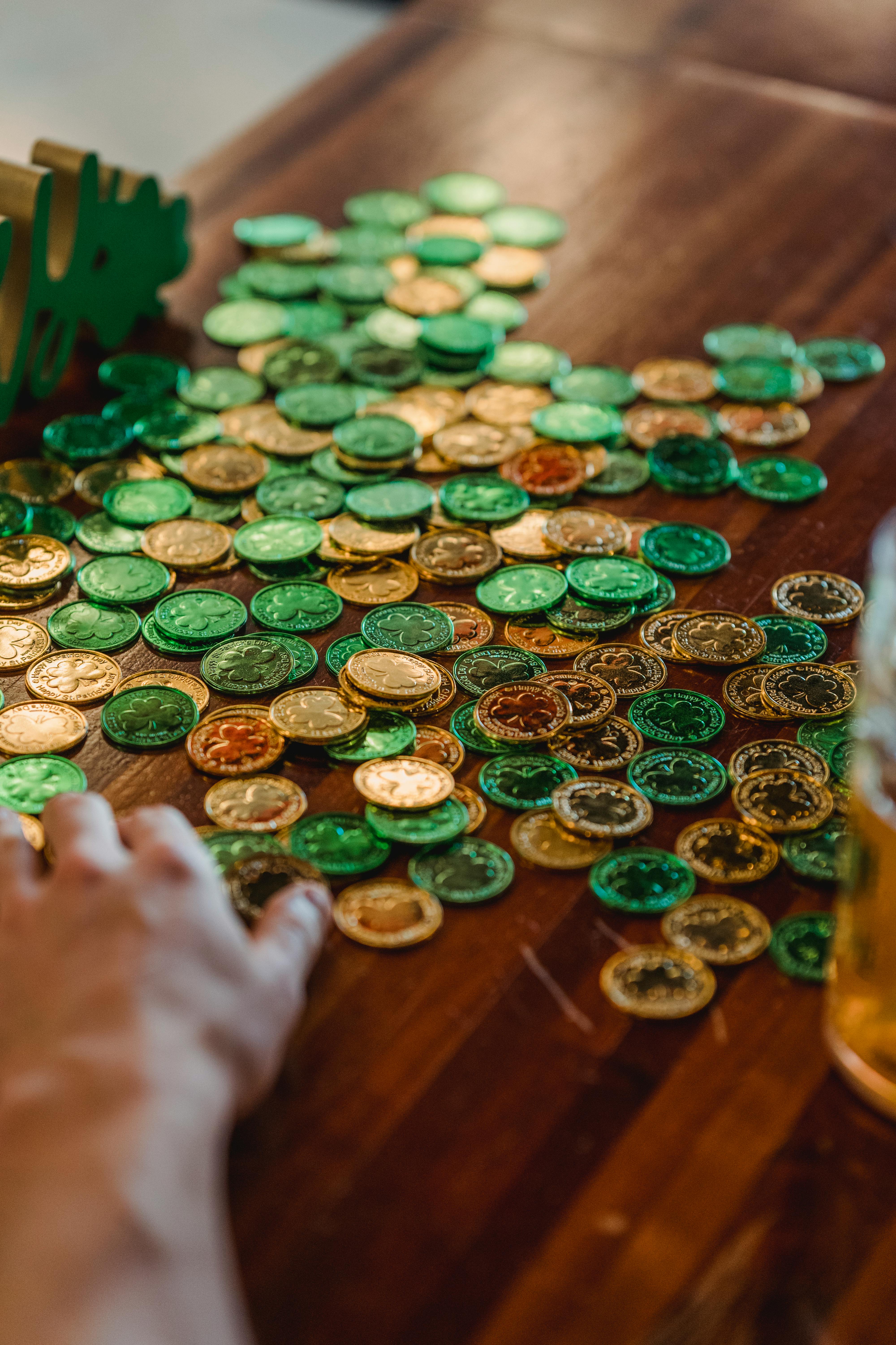 green and gold coins on wooden surface