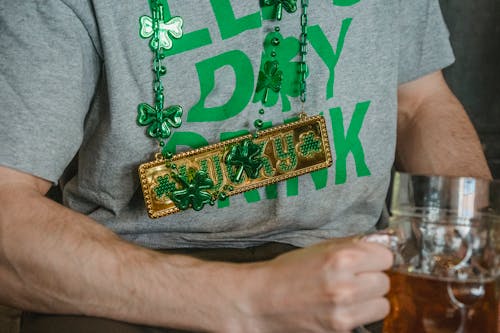 Close-Up Shot of Person Wearing a Gray Shirt and Shamrock Necklace