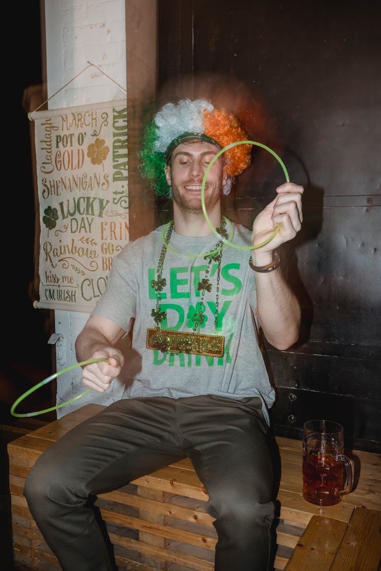 Cheerful Man Having Fun With Plastic Rings On Bench