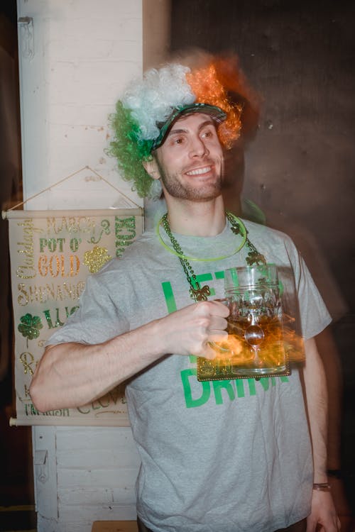 Smiling man in wig with beer on St Patricks Day
