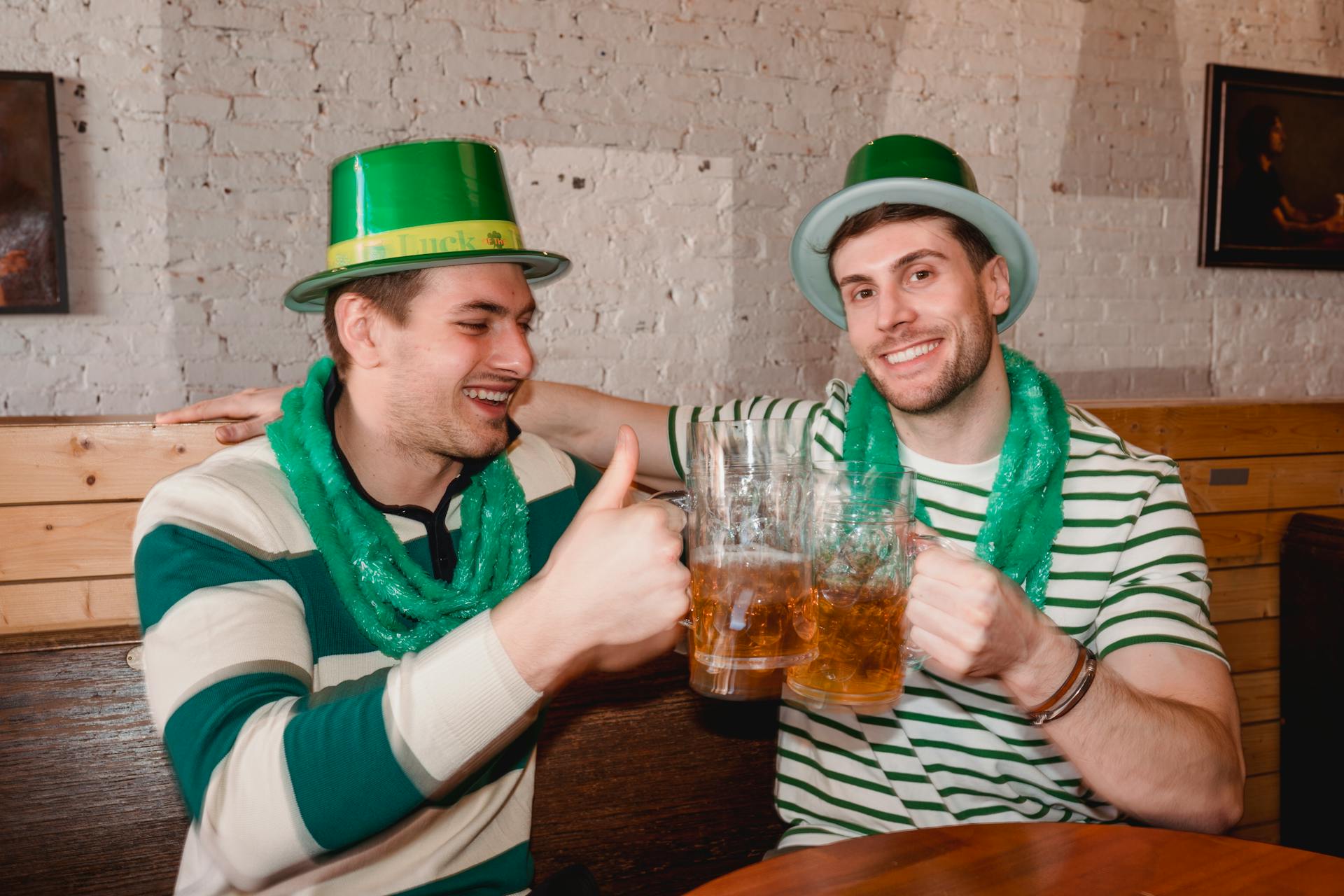 Happy friends clinking mugs of beer on Saint Patricks Day