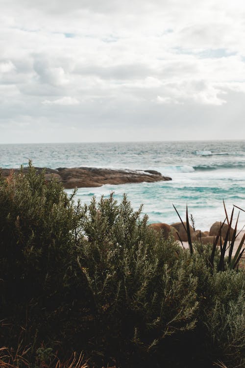 Stony shore washed by azure seawater on overcast day