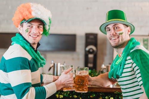 Joyful friends celebrating St Patricks day with glasses of beer